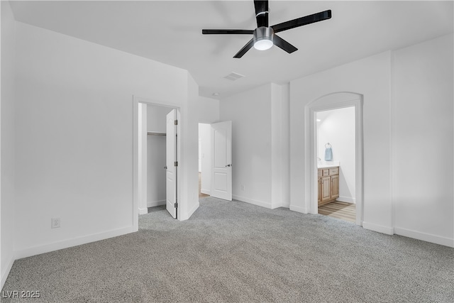 9047 Harbor Wind Ave, Las Vegas, NV 89178 - unfurnished bedroom featuring light colored carpet, a walk in closet, connected bathroom, ceiling fan, and a closet