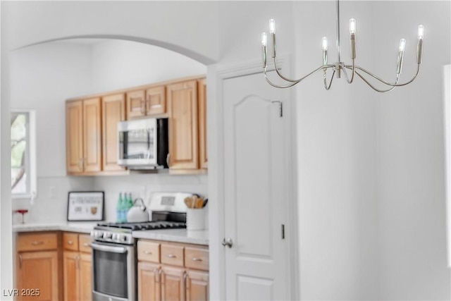 9047 Harbor Wind Ave, Las Vegas, NV 89178 - kitchen featuring appliances with stainless steel finishes, arched walkways, a chandelier, light countertops, and light brown cabinets