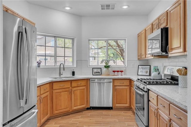9047 Harbor Wind Ave, Las Vegas, NV 89178 - kitchen with appliances with stainless steel finishes, light wood-type flooring, recessed lighting, tasteful backsplash, and light stone counters