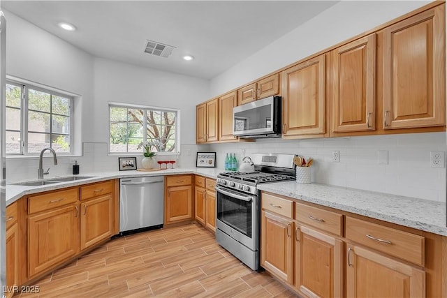 9047 Harbor Wind Ave, Las Vegas, NV 89178 - kitchen with stainless steel appliances, light stone countertops, decorative backsplash, light wood finished floors, and recessed lighting