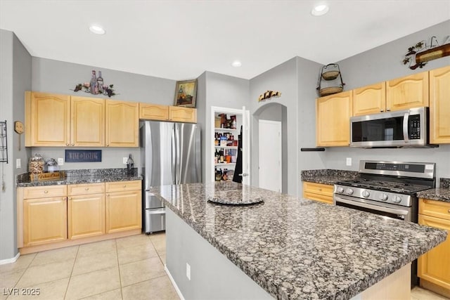 9408 Ironsend St, Las Vegas, NV 89143 - kitchen with stainless steel appliances, light brown cabinets, dark stone counters, a center island, and recessed lighting
