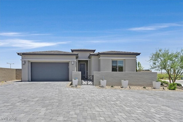 112 Springbough Ln, Las Vegas, NV 89138 - prairie-style house with a fenced front yard, decorative driveway, an attached garage, and stucco siding