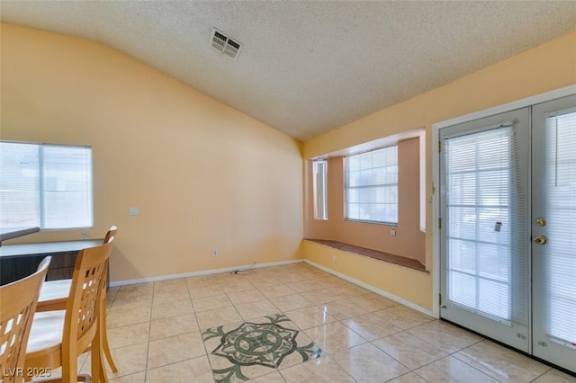 3127 Kennewick Dr, Las Vegas, NV 89121 - unfurnished dining area with vaulted ceiling, light tile patterned floors, a textured ceiling, and french doors