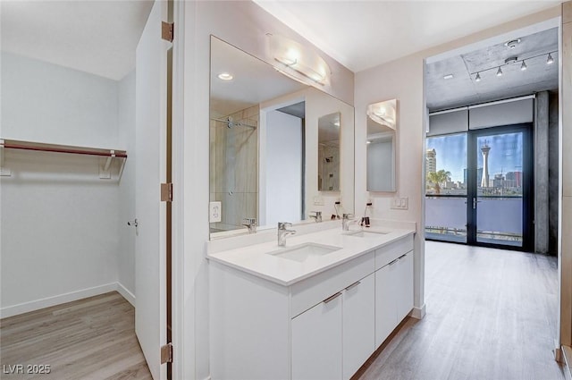 353 E Bonneville Ave Unit 449, Las Vegas, NV 89101 - bathroom featuring wood finished floors, double vanity, a shower, and a walk in closet