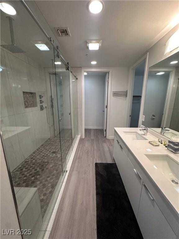 353 E Bonneville Ave Unit 449, Las Vegas, NV 89101 - bathroom featuring a stall shower, wood finished floors, and double vanity