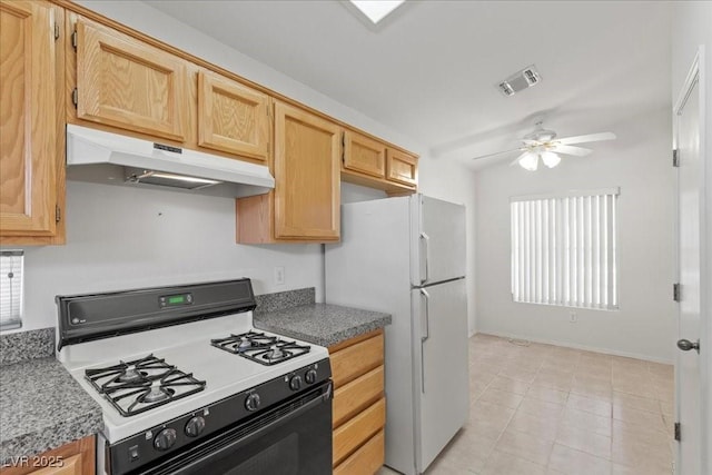 2154 Eagle Sticks Dr, Henderson, NV 89012 - kitchen with gas range, under cabinet range hood, a ceiling fan, freestanding refrigerator, and light tile patterned flooring