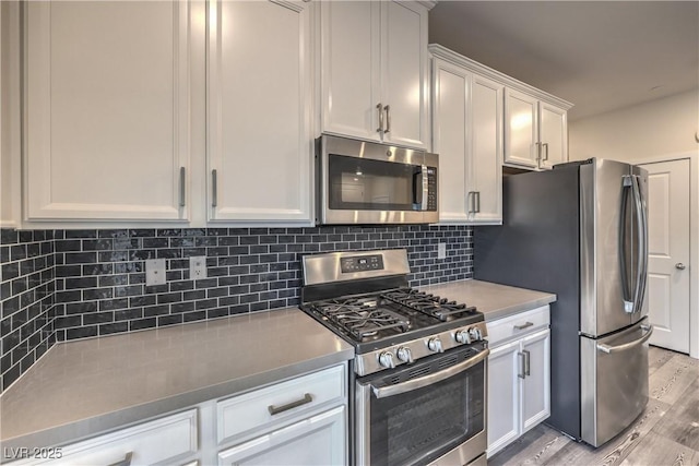 545 Thea St Unit 1315, Henderson, NV 89052 - kitchen with appliances with stainless steel finishes, light wood-style flooring, white cabinetry, and tasteful backsplash