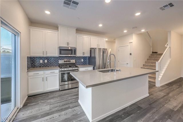 545 Thea St Unit 1315, Henderson, NV 89052 - kitchen with appliances with stainless steel finishes, an island with sink, white cabinets, light countertops, and tasteful backsplash
