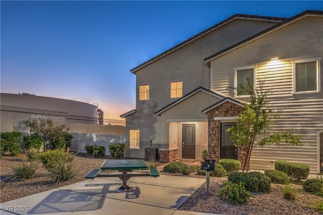 545 Thea St Unit 1315, Henderson, NV 89052 - back of property at dusk featuring a patio area, stone siding, and stucco siding