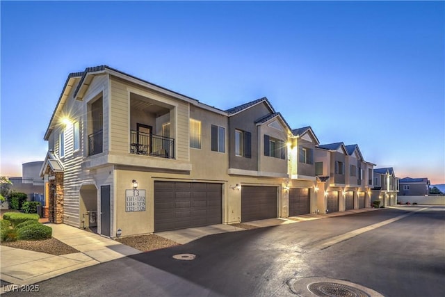 545 Thea St Unit 1315, Henderson, NV 89052 - view of front facade featuring a garage, a balcony, driveway, stucco siding, and a residential view