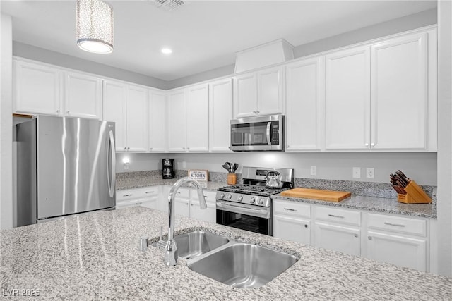 2404 Elmont Ave, North Las Vegas, NV 89086 - kitchen with appliances with stainless steel finishes, white cabinetry, light stone countertops, and recessed lighting