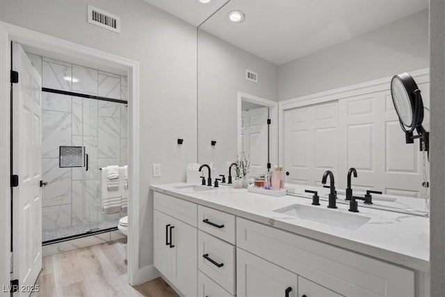 9540 Eagle Valley Dr, Las Vegas, NV 89134 - full bathroom featuring double vanity, a marble finish shower, wood finished floors, and recessed lighting