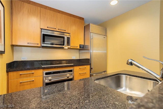 2000 Fashion Show Dr Unit 5022, Las Vegas, NV 89109 - kitchen with appliances with stainless steel finishes, dark stone counters, and brown cabinets