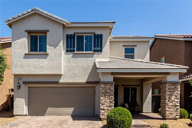 1034 Fish Pond Ave, Henderson, NV 89014 - view of front of home with a garage, stone siding, stucco siding, and driveway
