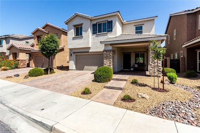 1034 Fish Pond Ave, Henderson, NV 89014 - view of front of home featuring stucco siding, a tile roof, an attached garage, driveway, and stone siding