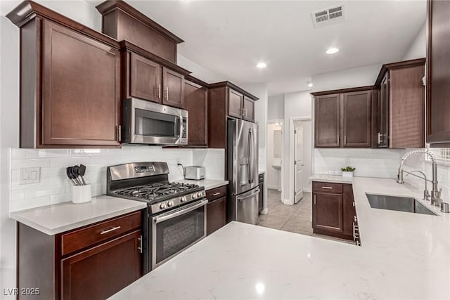 1034 Fish Pond Ave, Henderson, NV 89014 - kitchen with appliances with stainless steel finishes, backsplash, dark brown cabinets, and recessed lighting