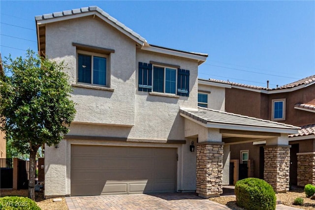 1034 Fish Pond Ave, Henderson, NV 89014 - view of front of home featuring a garage, stucco siding, stone siding, decorative driveway, and a tile roof