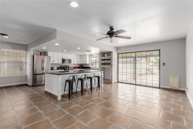 5905 Paseo Montana, Las Vegas, NV 89108 - kitchen featuring appliances with stainless steel finishes, recessed lighting, white cabinets, dark countertops, and a ceiling fan