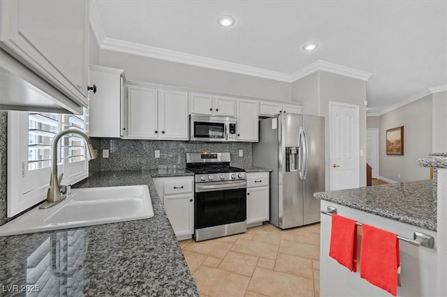 5918 Terra Grande Ave, Las Vegas, NV 89122 - kitchen with stainless steel appliances, white cabinets, decorative backsplash, ornamental molding, and stone tile flooring