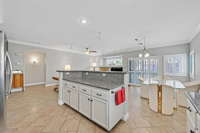 5918 Terra Grande Ave, Las Vegas, NV 89122 - kitchen featuring arched walkways, freestanding refrigerator, a ceiling fan, crown molding, and a center island
