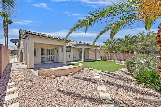 5918 Terra Grande Ave, Las Vegas, NV 89122 - back of property with a fenced backyard, a tile roof, stucco siding, a patio, and a gate