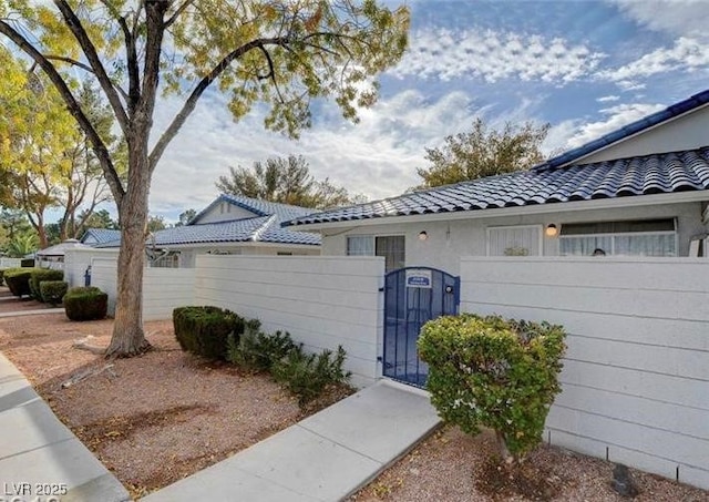 2132 Chertsey Dr Unit B, Las Vegas, NV 89108 - view of home's exterior featuring a tile roof and a gate