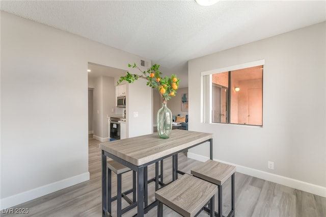 3151 Soaring Gulls Dr Unit 2180, Las Vegas, NV 89128 - dining space with light wood-style floors and a textured ceiling