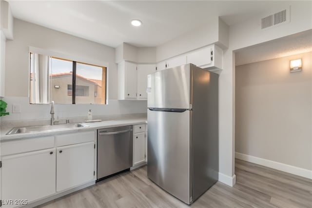 3151 Soaring Gulls Dr Unit 2180, Las Vegas, NV 89128 - kitchen with stainless steel appliances, light wood-style flooring, white cabinets, light countertops, and recessed lighting