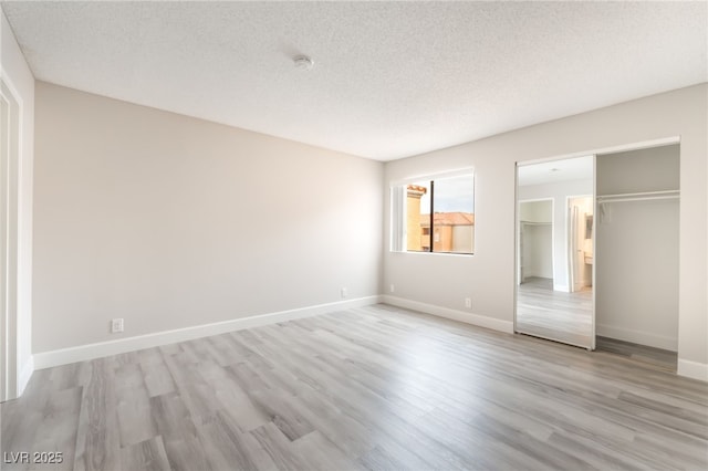 3151 Soaring Gulls Dr Unit 2180, Las Vegas, NV 89128 - unfurnished bedroom featuring light wood-style flooring, a textured ceiling, and a closet