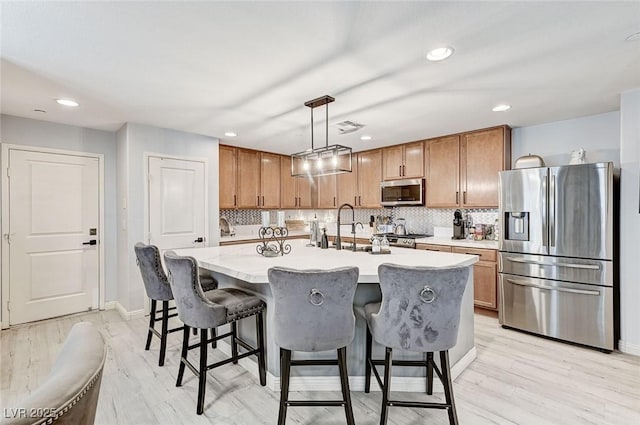 2370 Via Firenze, Henderson, NV 89044 - kitchen featuring stainless steel appliances, recessed lighting, light countertops, a center island with sink, and pendant lighting