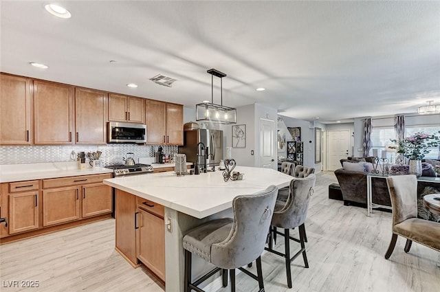 2370 Via Firenze, Henderson, NV 89044 - kitchen featuring appliances with stainless steel finishes, light wood-type flooring, a kitchen breakfast bar, pendant lighting, and recessed lighting