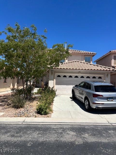9940 Trailing Vine St, Las Vegas, NV 89183 - view of front facade with an attached garage, driveway, a tiled roof, and stucco siding
