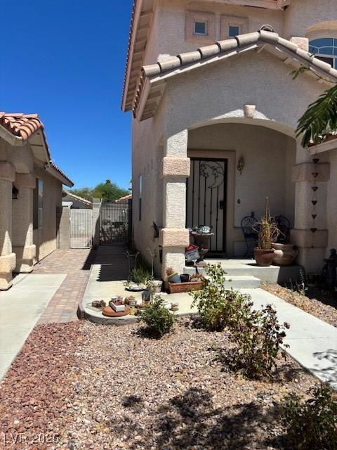 9940 Trailing Vine St, Las Vegas, NV 89183 - doorway to property featuring a gate and stucco siding