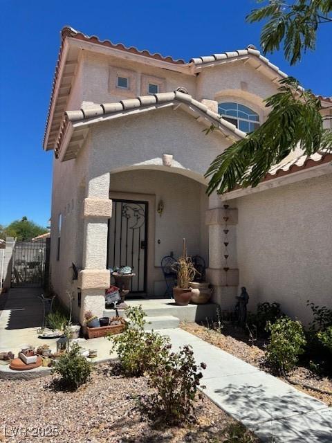 9940 Trailing Vine St, Las Vegas, NV 89183 - mediterranean / spanish home with a gate, a tile roof, and stucco siding
