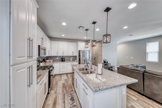 6335 Pacific Sky St, North Las Vegas, NV 89081 - kitchen featuring appliances with stainless steel finishes, white cabinetry, light wood-style flooring, tasteful backsplash, and recessed lighting