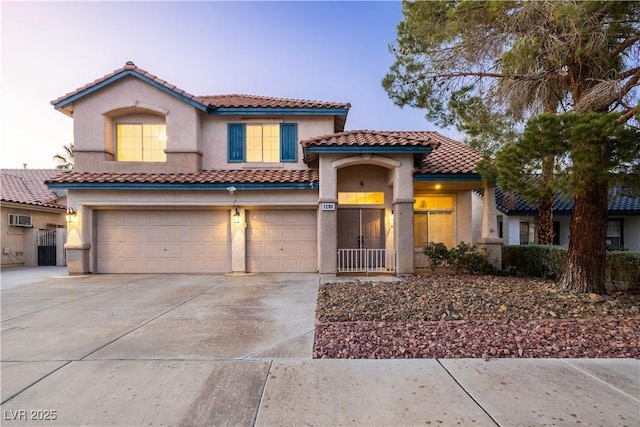 1206 Evening Canyon Ave, Henderson, NV 89014 - mediterranean / spanish-style home featuring an attached garage, concrete driveway, stucco siding, a tile roof, and a wall mounted AC