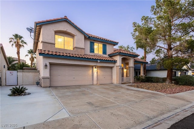 1206 Evening Canyon Ave, Henderson, NV 89014 - mediterranean / spanish home featuring a tile roof, stucco siding, an attached garage, concrete driveway, and a gate