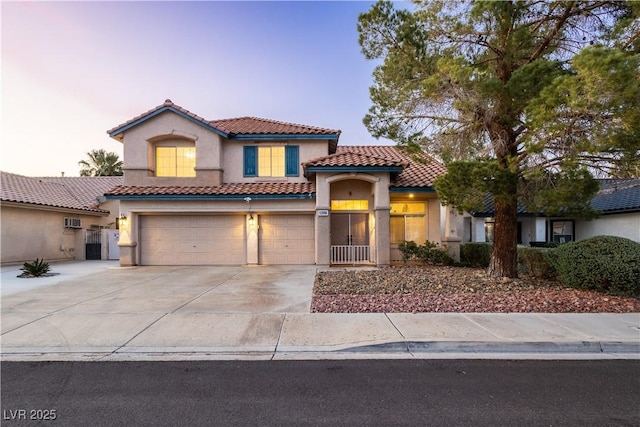 1206 Evening Canyon Ave, Henderson, NV 89014 - mediterranean / spanish-style home featuring a garage, a tiled roof, stucco siding, driveway, and a wall unit AC