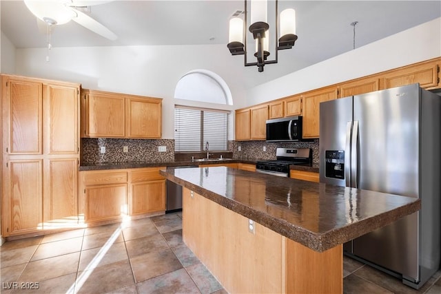 1206 Evening Canyon Ave, Henderson, NV 89014 - kitchen with appliances with stainless steel finishes, dark countertops, a towering ceiling, backsplash, and a center island