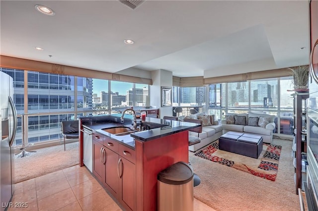 4575 Dean Martin Dr Unit 1112, Las Vegas, NV 89103 - kitchen featuring appliances with stainless steel finishes, dark countertops, open floor plan, light tile patterned floors, and a city view