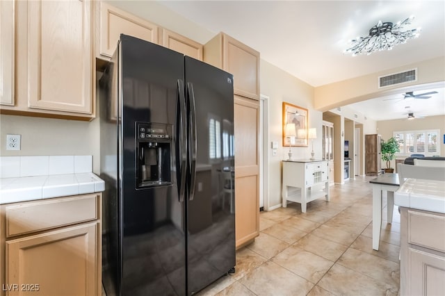 7450 S Eastern Ave Unit 1058, Las Vegas, NV 89123 - kitchen featuring black fridge with ice dispenser, tile counters, ceiling fan, light brown cabinets, and arched walkways