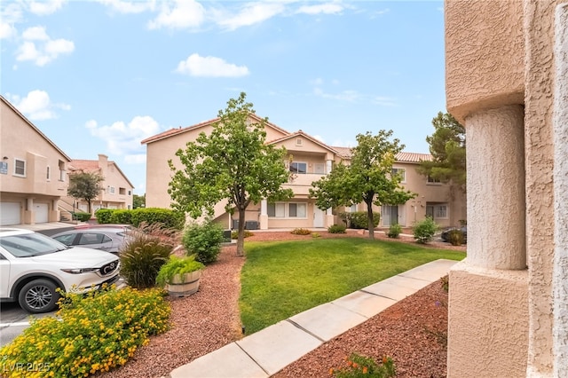 7450 S Eastern Ave Unit 1058, Las Vegas, NV 89123 - view of front of home with a residential view, stucco siding, uncovered parking, and a front lawn