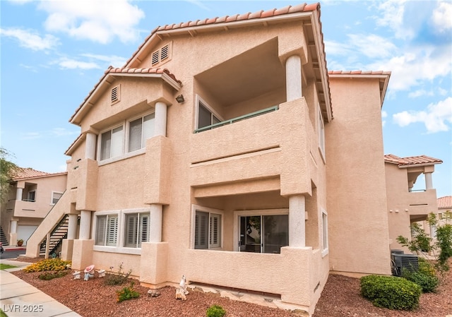 7450 S Eastern Ave Unit 1058, Las Vegas, NV 89123 - view of side of home with a tiled roof, stucco siding, and stairs