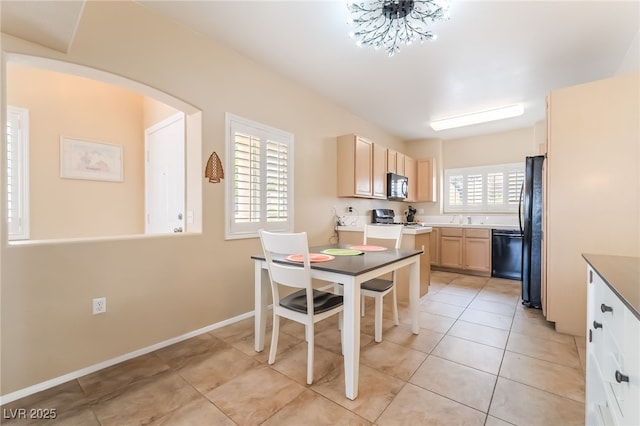 7450 S Eastern Ave Unit 1058, Las Vegas, NV 89123 - kitchen featuring black appliances, light brown cabinetry, arched walkways, and light tile patterned flooring