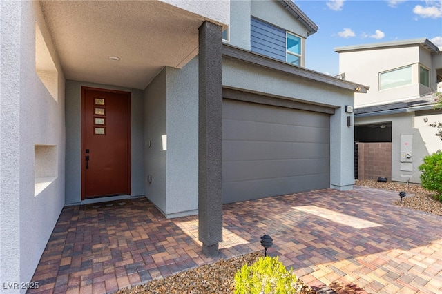 2004 Peaceful Mesa Ct, Henderson, NV 89052 - view of exterior entry with stucco siding, an attached garage, and decorative driveway
