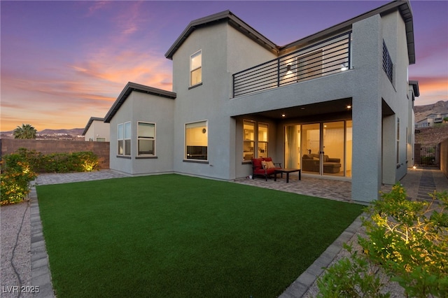 2004 Peaceful Mesa Ct, Henderson, NV 89052 - rear view of property featuring a balcony, a patio area, a fenced backyard, and stucco siding