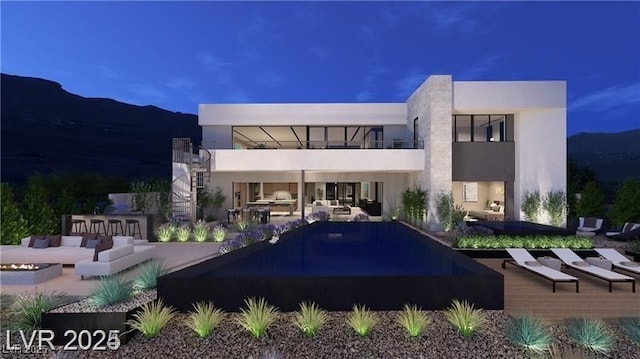 611 Grand Rim Dr, Henderson, NV 89012 - back of house at night featuring a balcony, stucco siding, a patio, and a mountain view