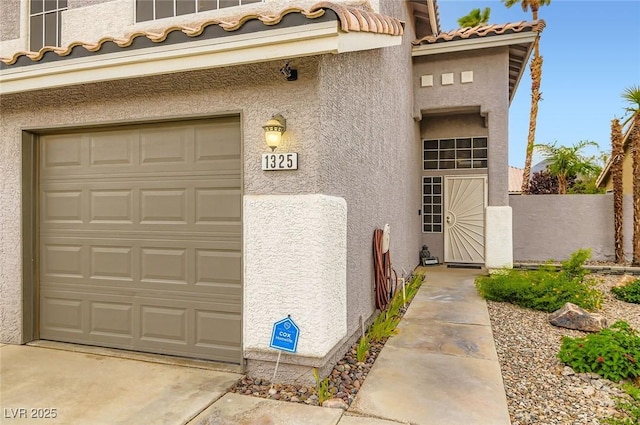 1325 Baychester Dr, Henderson, NV 89002 - property entrance featuring stucco siding, a tiled roof, a garage, and concrete driveway