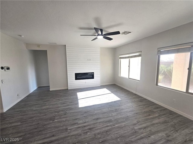3544 Tack St, Las Vegas, NV 89122 - unfurnished living room with ceiling fan, dark wood-style flooring, a large fireplace, and a textured ceiling