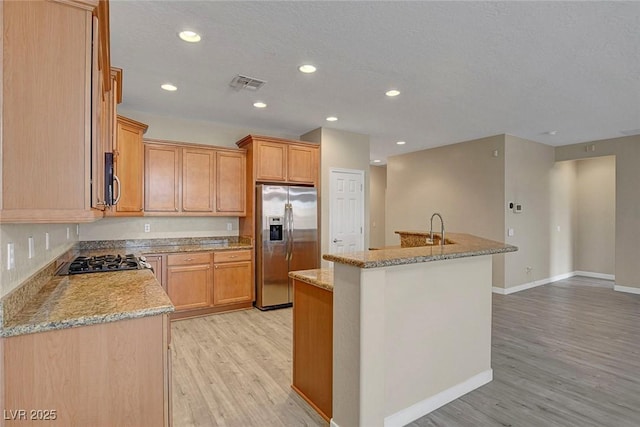 3544 Tack St, Las Vegas, NV 89122 - kitchen with stainless steel appliances, light wood-style flooring, recessed lighting, a kitchen island with sink, and light stone counters